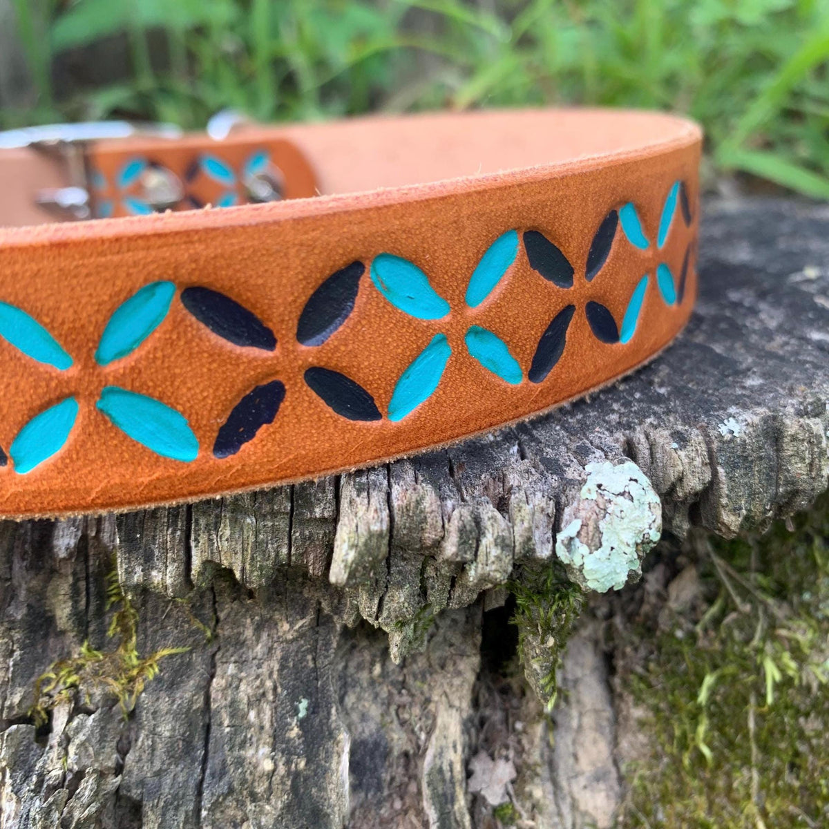 A close-up of a Colorful leather dog collar that is hand-painted dark blue and teal.
